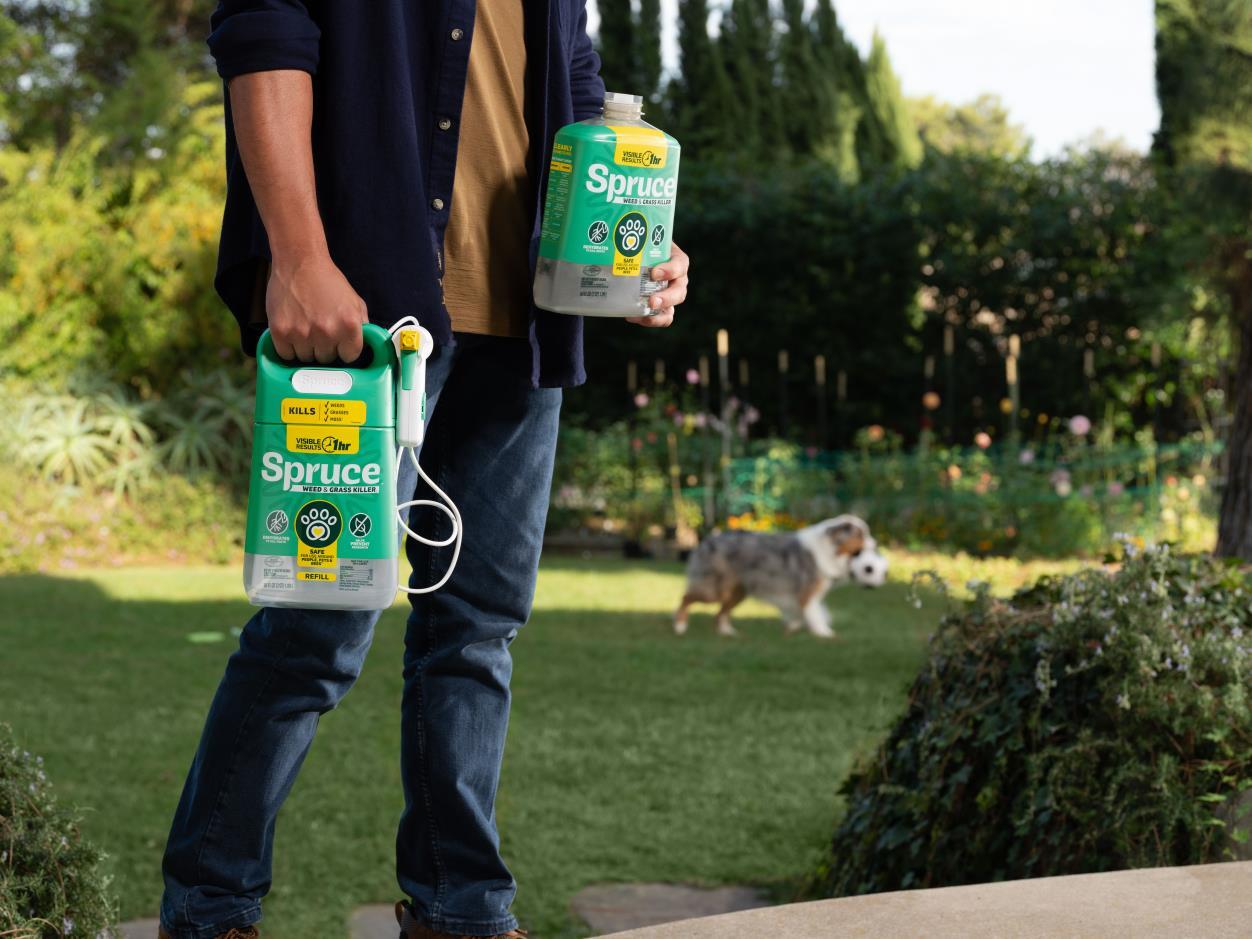 Person holding Spruce Manual Weed & Grass Killer Spray and Spruce Weed & Grass Killer Refill