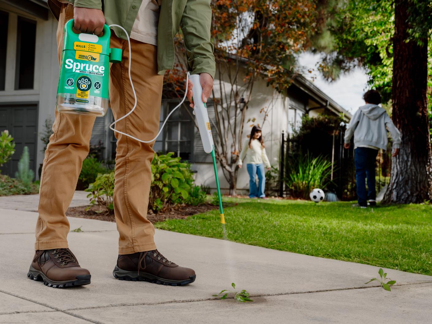 Spruce Weed & Grass Killer Power Spray Product being used on weed on sidewalk crack.